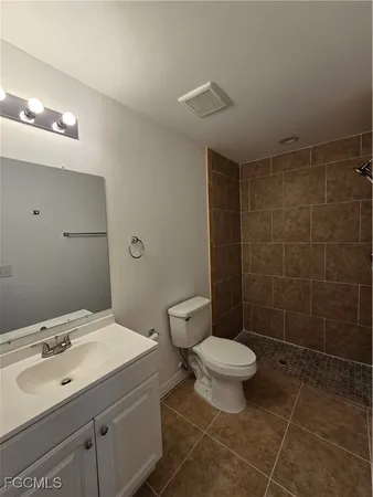 a bathroom with a sink a toilet a mirror and shower