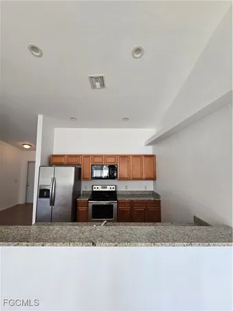 a kitchen with stainless steel appliances granite countertop a sink a stove and a refrigerator