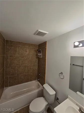 a bathroom with a toilet and a bath tub