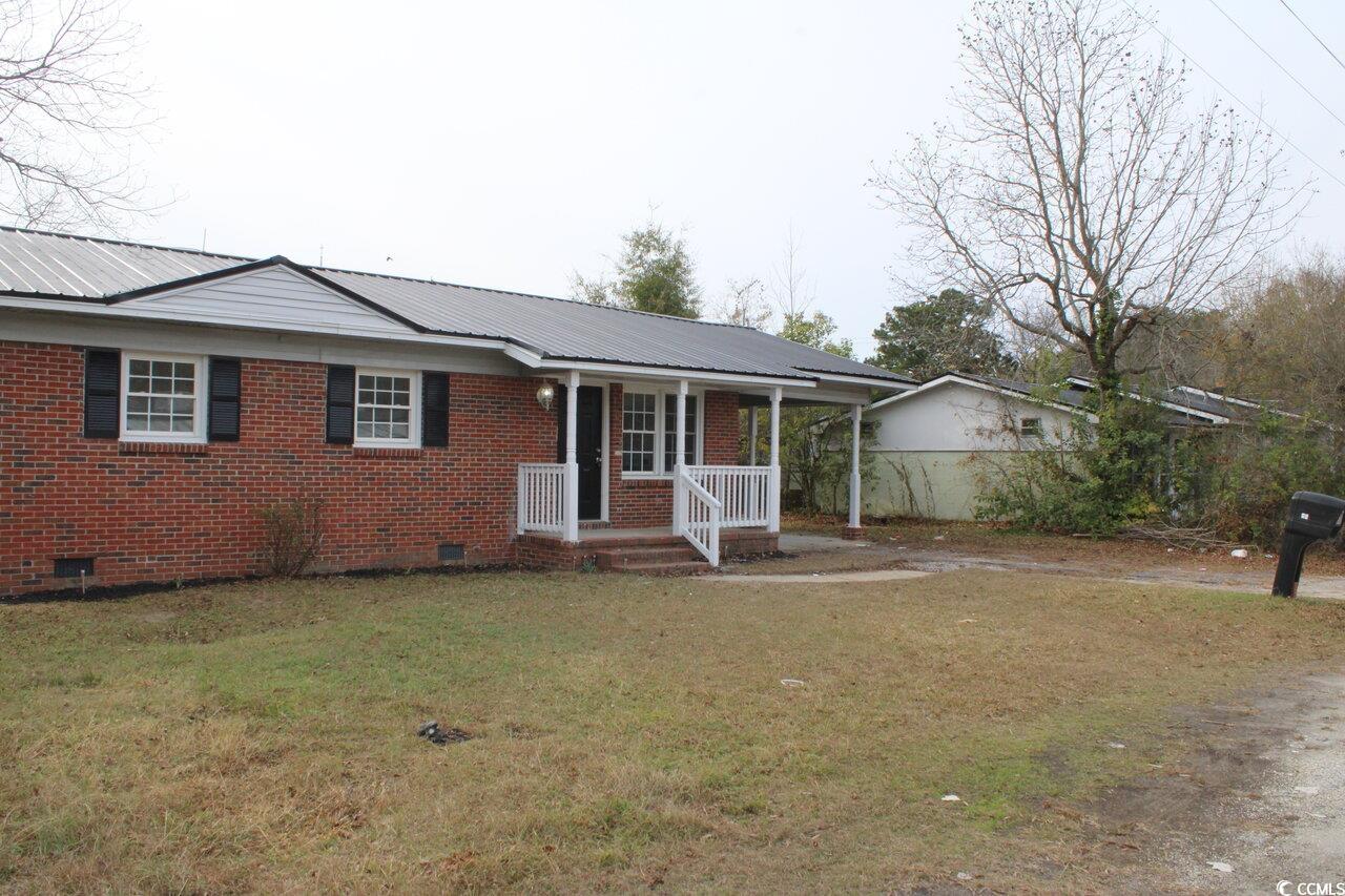 105 Mace Court Latta, SC 29565 - Photo 2 of 12 Ranch-style home with crawl space, covered porch, a front lawn, and a metal roof