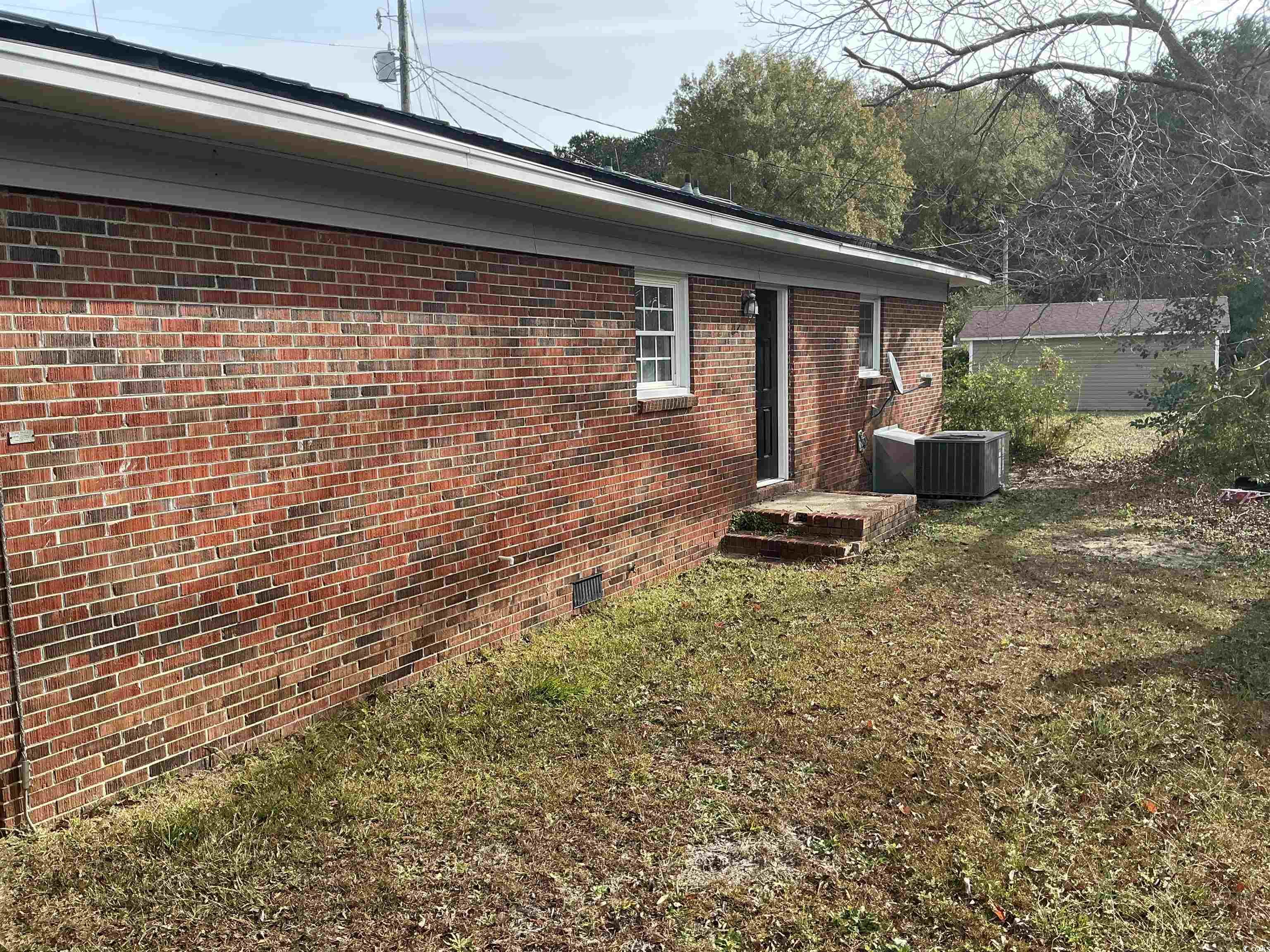 105 Mace Court Latta, SC 29565 - Photo 4 of 12 View of side of home featuring crawl space, brick siding, and a lawn