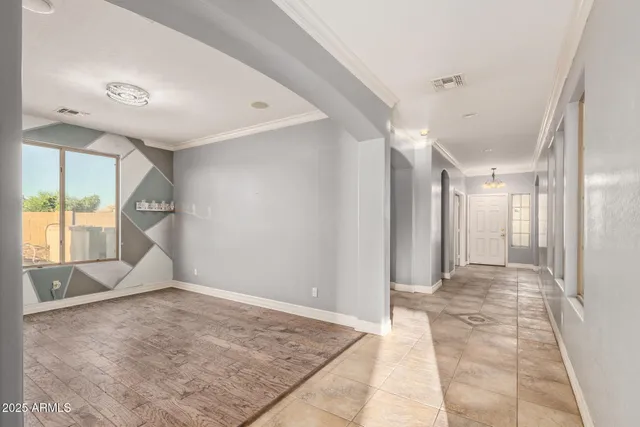 a view of an empty room with a window and chandelier