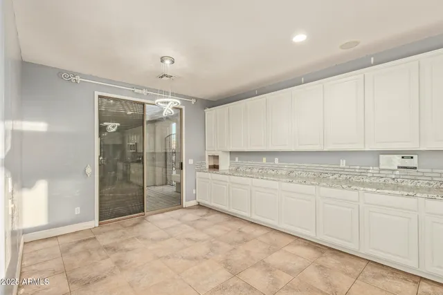 a large kitchen with granite countertop a stove a sink dishwasher and a refrigerator with wooden floor