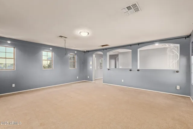 a view of an empty room with closet and bathroom