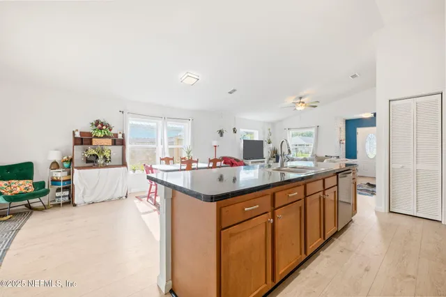a living room with stainless steel appliances furniture a fireplace and a flat screen tv