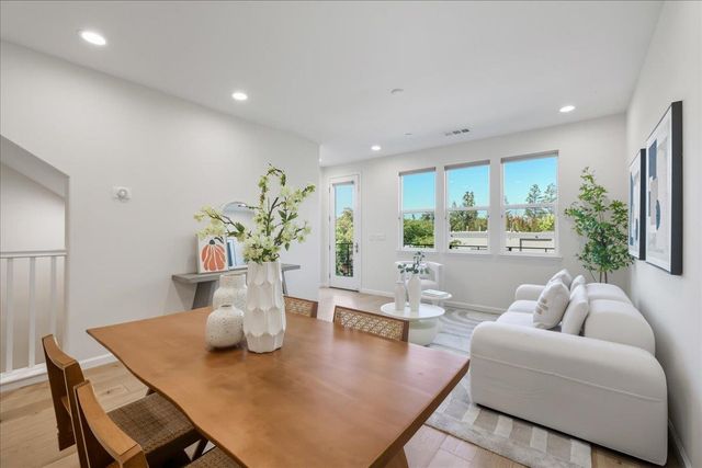 a dining room with wooden floor and a potted plant