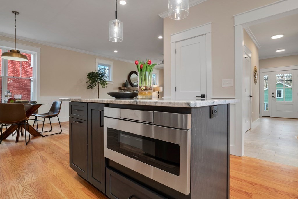 297 Riverside Drive Northampton, MA 01062 - Photo 14 of 32 a kitchen with kitchen island stainless steel appliances a dining table chairs sink and wooden floor