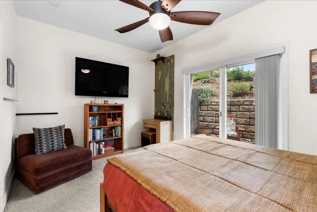 a bedroom with a bed a flat screen tv and a chandelier