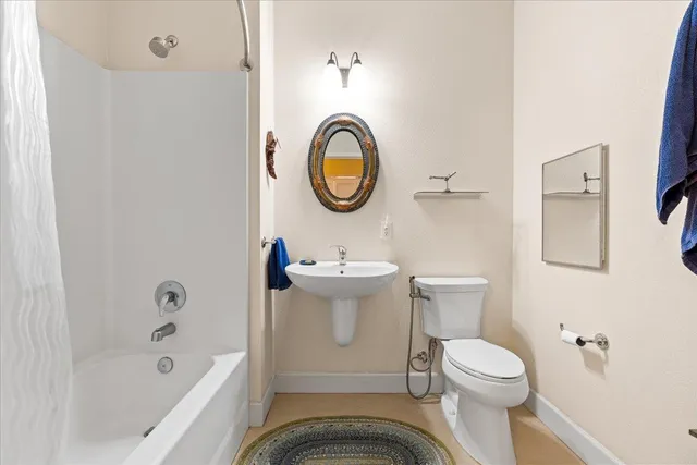 a bathroom with a sink a toilet and a mirror