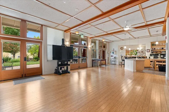 a view of a living room and kitchen with furniture wooden floor and a large window