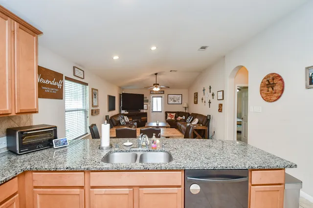 a kitchen with granite countertop a sink and white cabinets