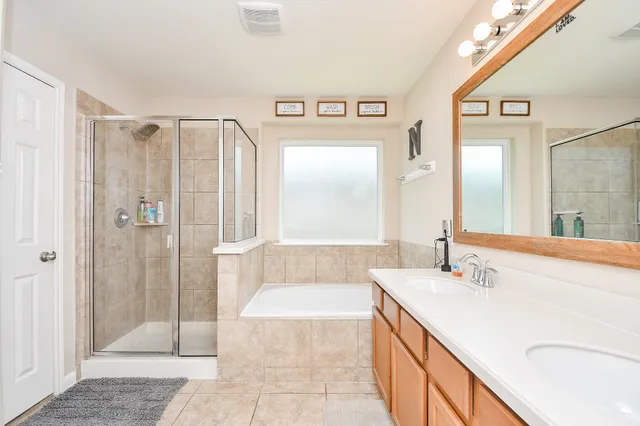 a bathroom with a granite countertop sink mirror and a bathtub