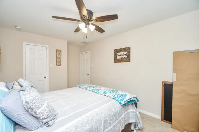 a bedroom with a large bed and a chandelier