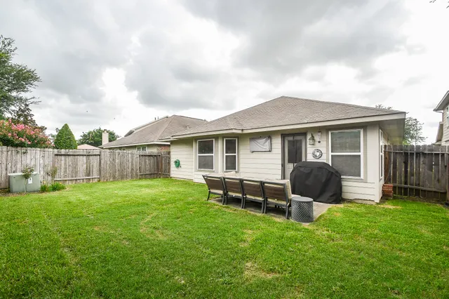 a backyard of a house with table and chairs