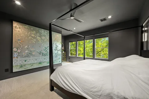 a bedroom with a bed and a large window