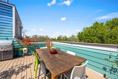 a view of a balcony with wooden floor and outdoor seating