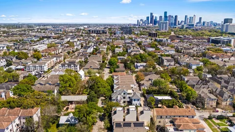 an aerial view of residential houses with outdoor space and trees