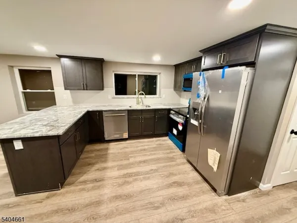 a large kitchen with a stove a refrigerator and a sink