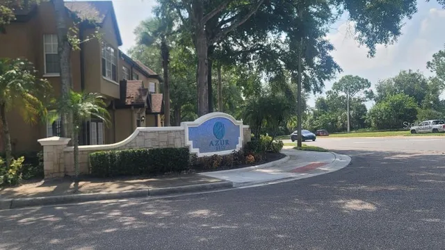 a front view of a house with a yard and large tree