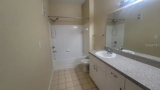 a bathroom with a granite countertop sink a toilet and shower