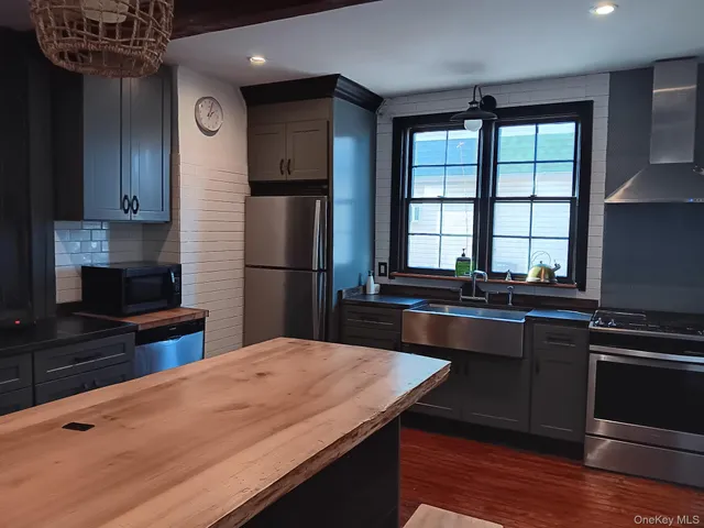 a kitchen with kitchen island a sink appliances and cabinets