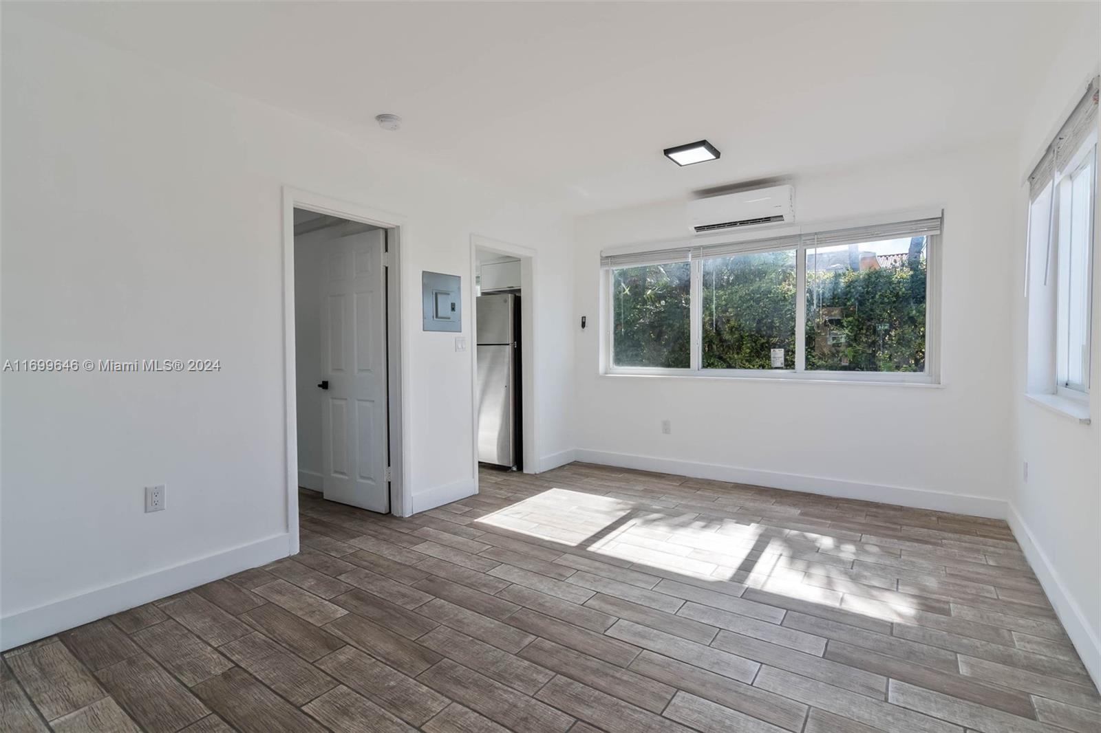 2190 Southwest 14th Terrace, Unit 1 Miami, FL 33145 - Photo 3 of 13 an empty room with wooden floor and windows