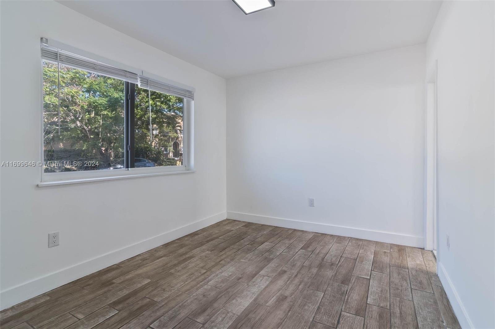 2190 Southwest 14th Terrace, Unit 1 Miami, FL 33145 - Photo 7 of 13 an empty room with wooden floor and windows