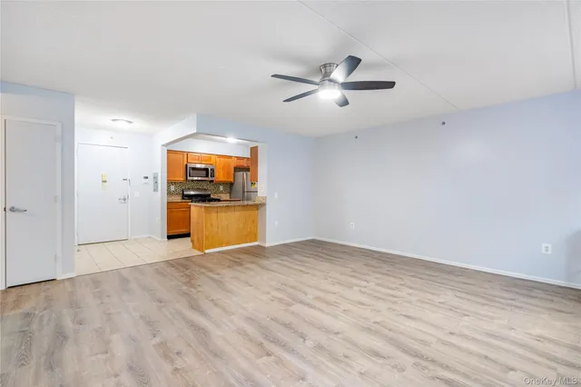 a view of empty room with wooden floor and window