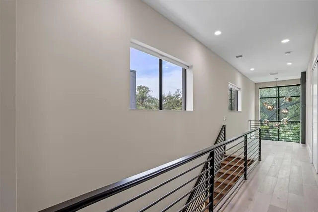 a view of a hallway with wooden floor and a window