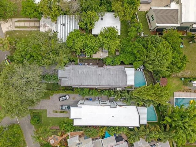 an aerial view of a city with lots of residential buildings ocean and mountain view in back