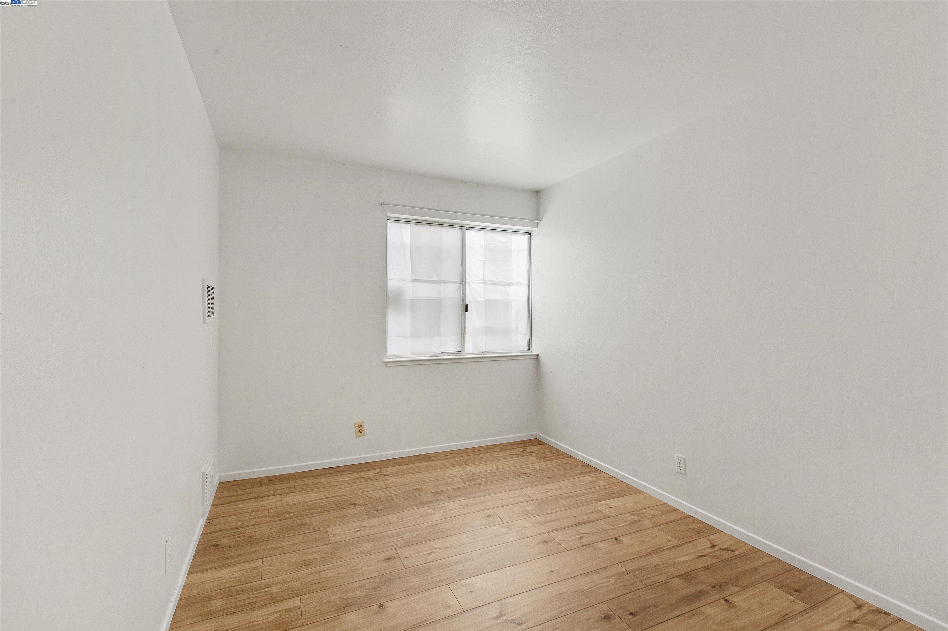 1540 O'Farrell Street, Unit 1 San Francisco, CA 94115 - Photo 7 of 19 an empty room with wooden floor and window