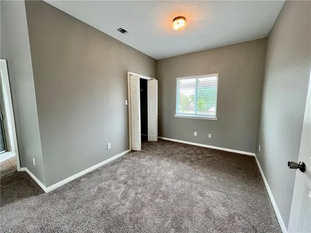 an empty room with windows and closet