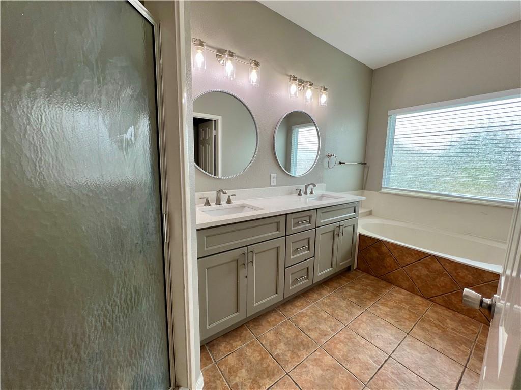 1706 Winners Ribbon Circle Pflugerville, TX 78660 - Photo 18 of 21 a bathroom with a double vanity sink mirror and shower
