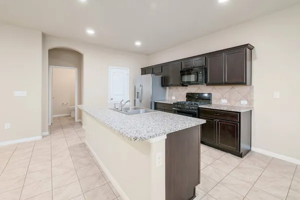 a kitchen with stainless steel appliances granite countertop a refrigerator and a sink