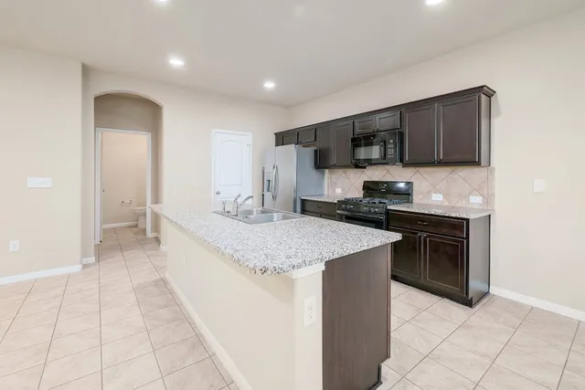 a kitchen with stainless steel appliances granite countertop a refrigerator and a sink