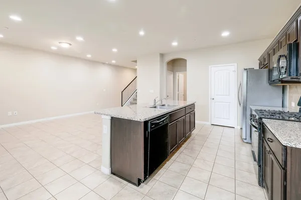 a kitchen with stainless steel appliances granite countertop a sink and a stove