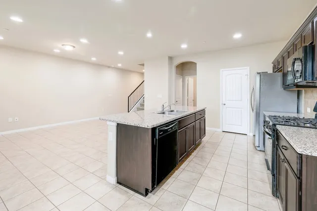 a kitchen with stainless steel appliances granite countertop a sink and a stove