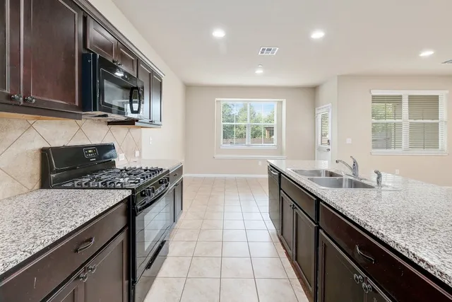 a kitchen with stainless steel appliances granite countertop a sink and a stove