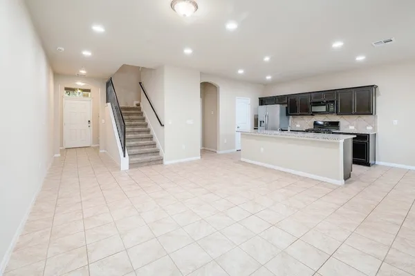 a large white kitchen with a stove a sink and a refrigerator