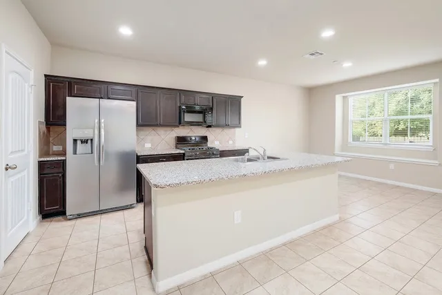 a kitchen with stainless steel appliances granite countertop a sink and cabinets