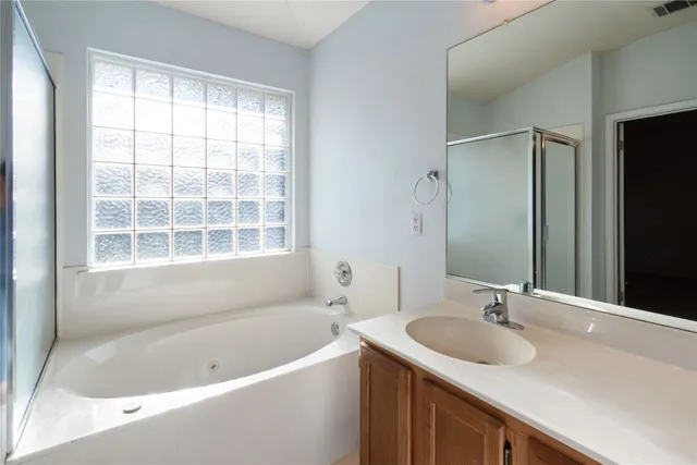 a bathroom with a tub sink and mirror