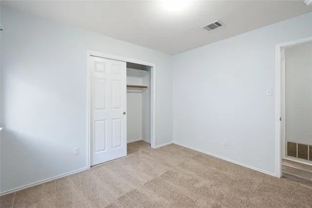 a room with walk in closet and wooden floor