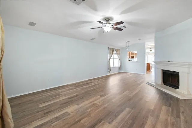 a view of empty room with wooden floor and fireplace