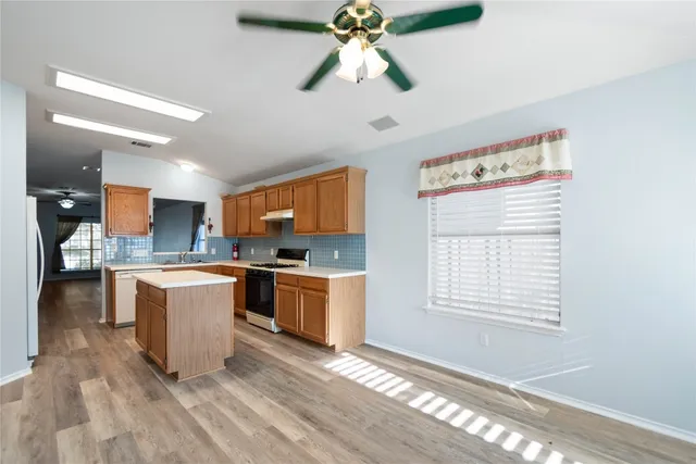 a kitchen with kitchen island white cabinets and wooden floor