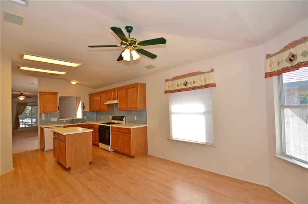 3609 Ruby Red Drive Austin, TX 78728 - Photo 8 of 21 Kitchen with a ceiling fan, light countertops, backsplash, lofted ceiling, and range with gas cooktop