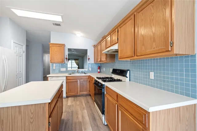 a kitchen with a stove a sink a refrigerator and cabinets