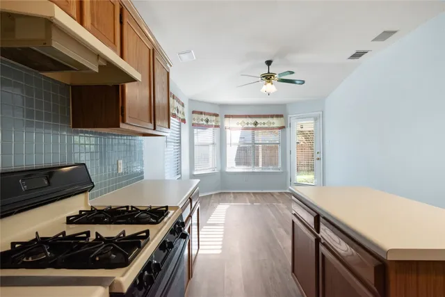 a kitchen with sink stove and cabinets
