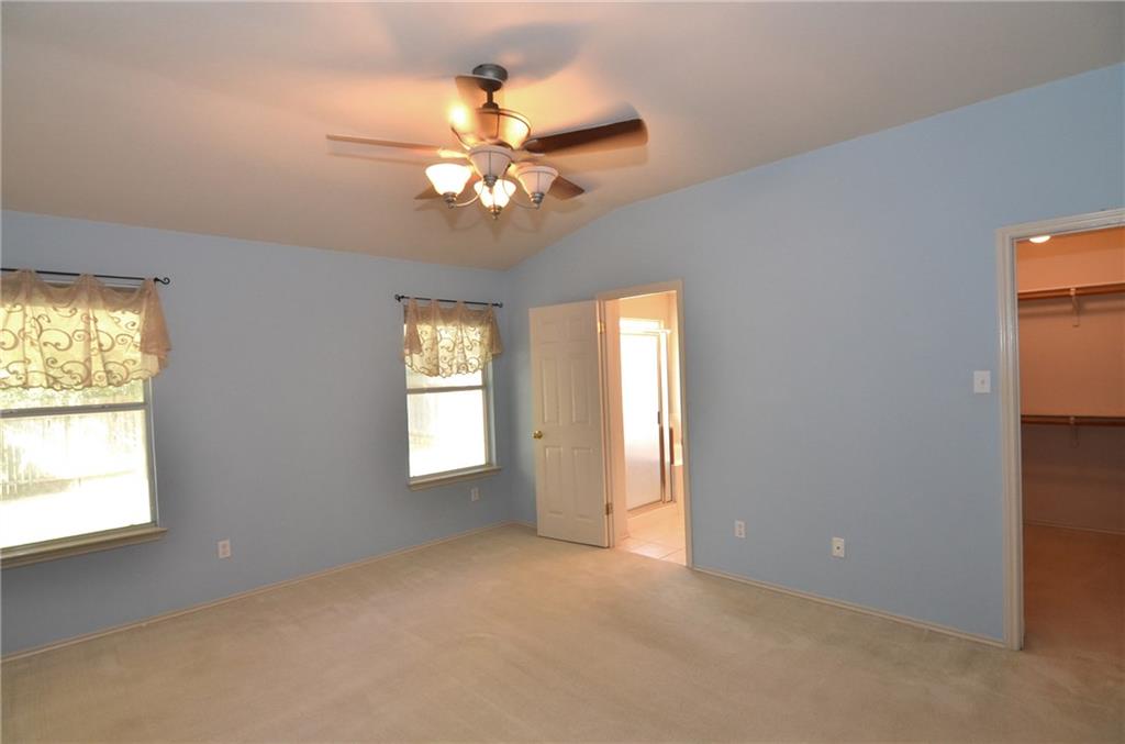 3609 Ruby Red Drive Austin, TX 78728 - Photo 9 of 21 Unfurnished bedroom featuring a spacious closet, lofted ceiling, carpet floors, and a ceiling fan