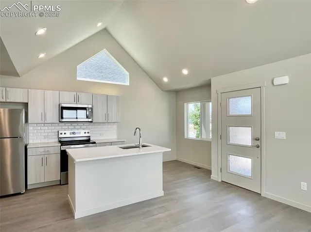 a kitchen with stainless steel appliances granite countertop a sink stove and refrigerator
