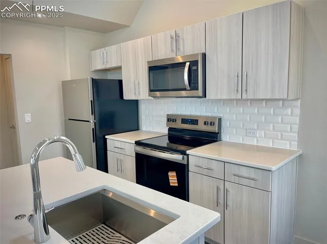 a kitchen with a sink a stove and refrigerator